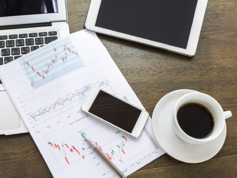 Laptop, tablet , smartphone and coffee cup with financial docume